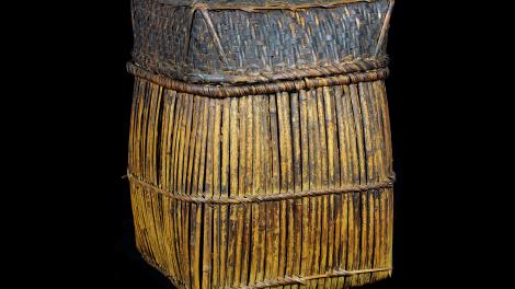 A tall square basket that tapers out slightly to bottom and curves under. 